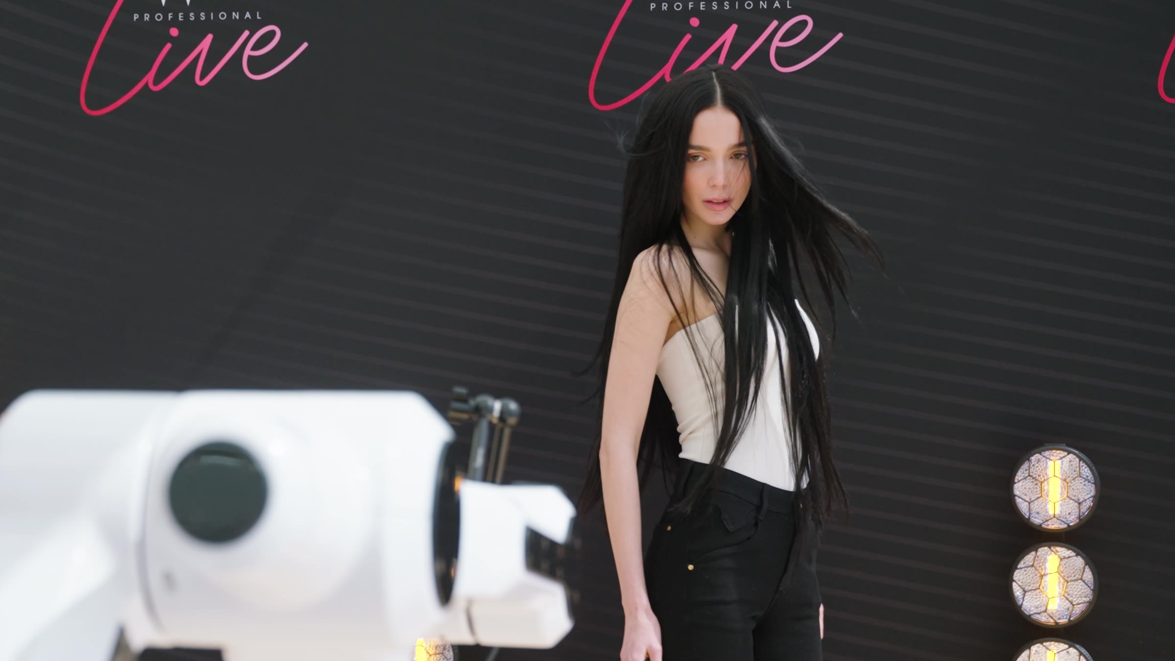 A model at the glambot rig in front of the Beauty Works Professional Live backdrop
