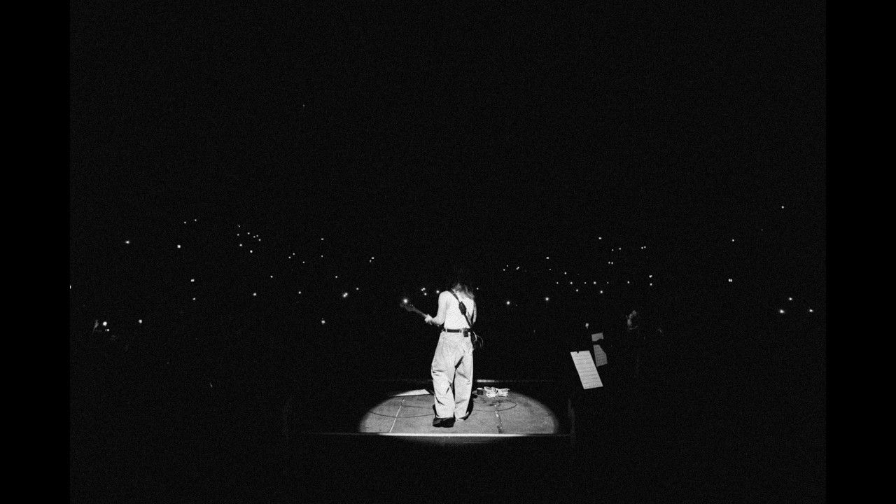 Sam Ryder alone on a lit stage in a darkened Wembley Arena